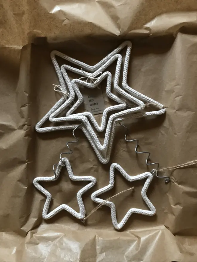 String & wire Triple Star tree topper packaged in a shallow box lined with brown tissue paper