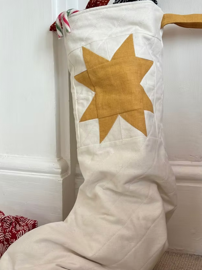 Large Star Linen Quilted Christmas Stockings. A white and yellow stocking.