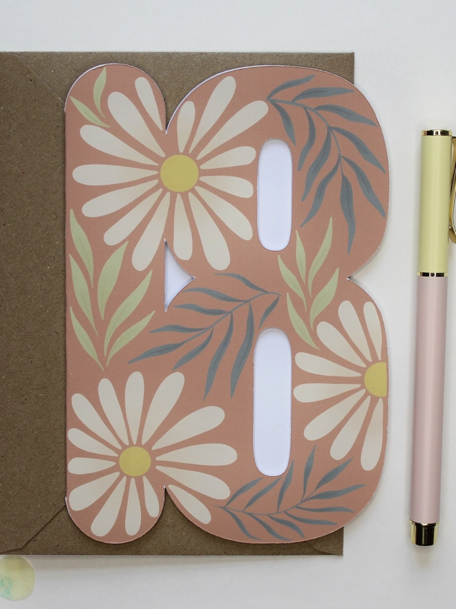 floral 18th birthday card. card shaped like number 18 with daisies and leaves.