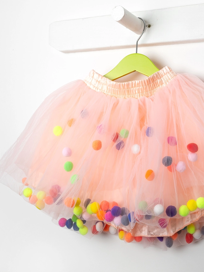 Peach pom pom tutu hanging with neon pom poms 