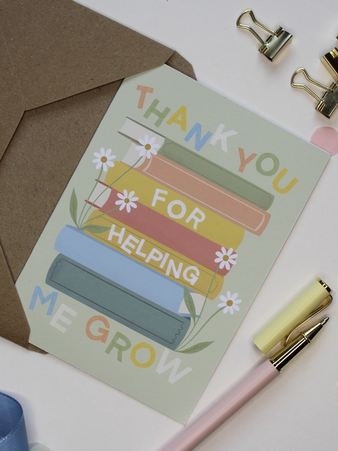 'thank you for helping me grow' illustrated card. green card with illustrated books and flowers.