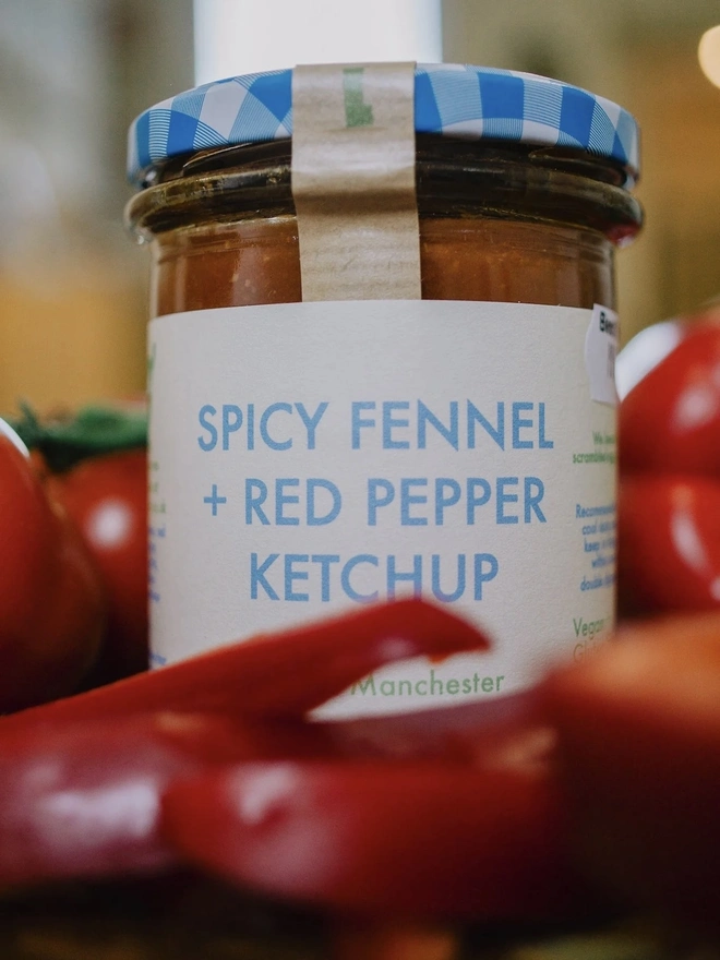 Spicy Fennel & Red Pepper Ketchup Jar, seasoning jar surrounded by peppers. 