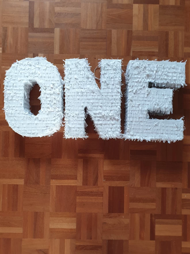 first birthday pinatas spelling out the word ONE