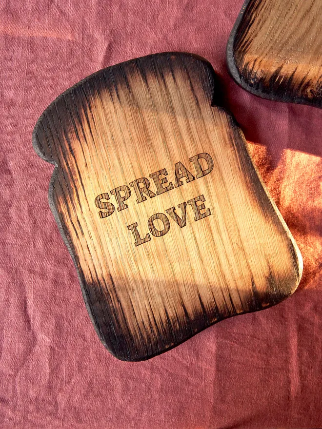 Spread love toast shaped serving board. A wooden toast shaped serving board with spread love engraved on the front