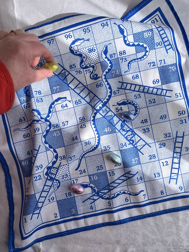 playing the game snakes and ladders napkin with mini easter eggs