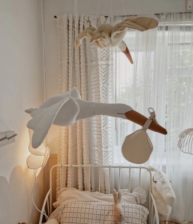 Flying Stork Hanging Decoration, a hanging stork decoration suspended in a child's bedroom. 