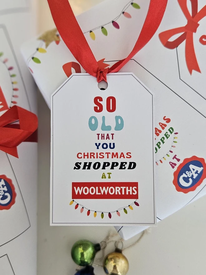 A gift tag on a present says so old that you Christmas shopped at Woolworths  to match the paper.