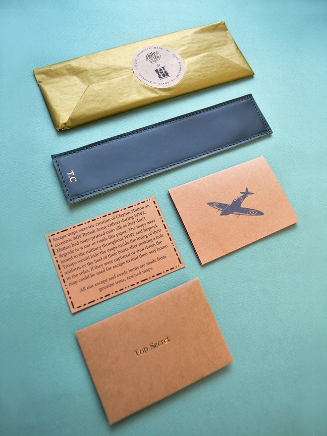 gift wrapped escape silk map bookmark with a gift card and information about the maps