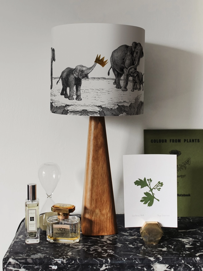 Handmade lampshade featuring adorable mischievous baby elephants playing together, inspired by Whipsnade Zoo, with a playful animal design.