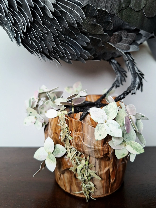 Tree stump ado4ned with mottled green hydrangea paper flowers