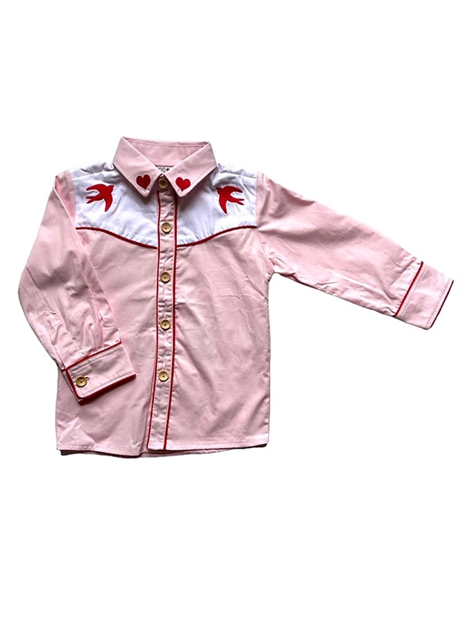 A pink and white cowgirl shirt with red piping and heart and swallow embroidery