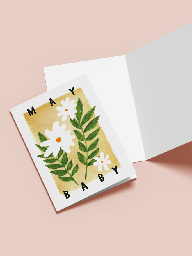 may baby illustrated card. a yellow card with white flowers in the centre.