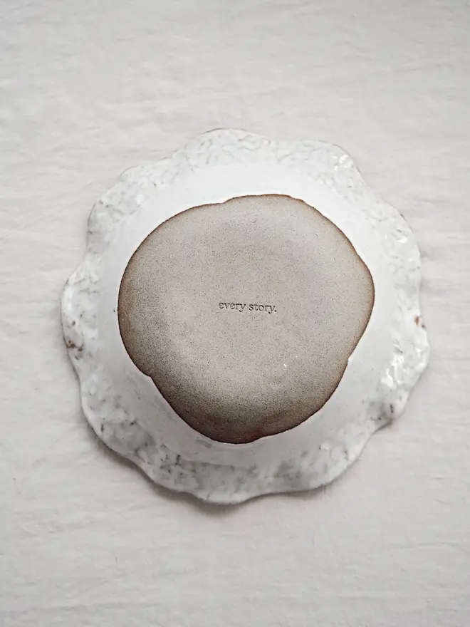 Dapple Stoneware Pasta Bowl, turned upside down placed on a table cloth. 