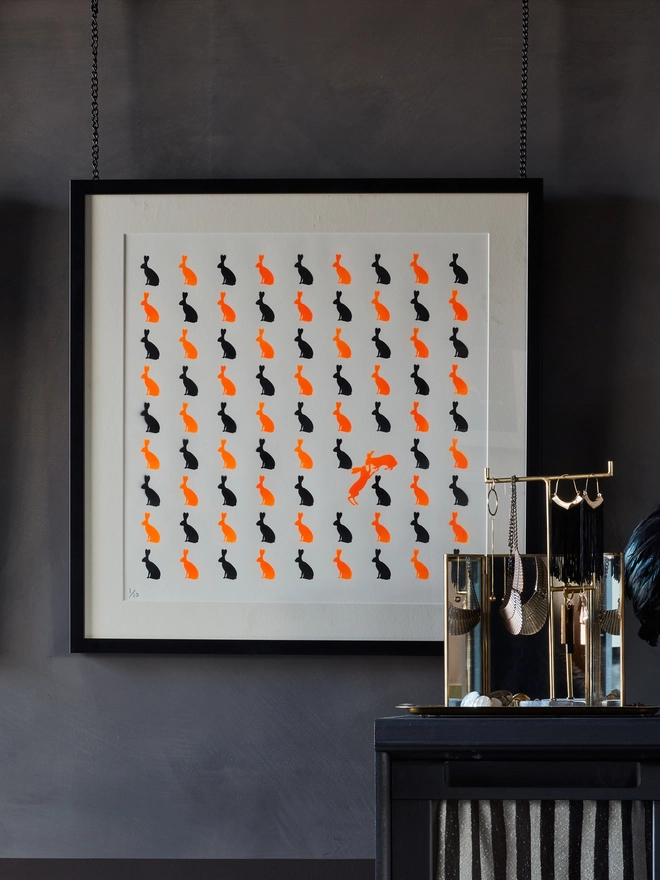 Orange bunnies framed on a wall