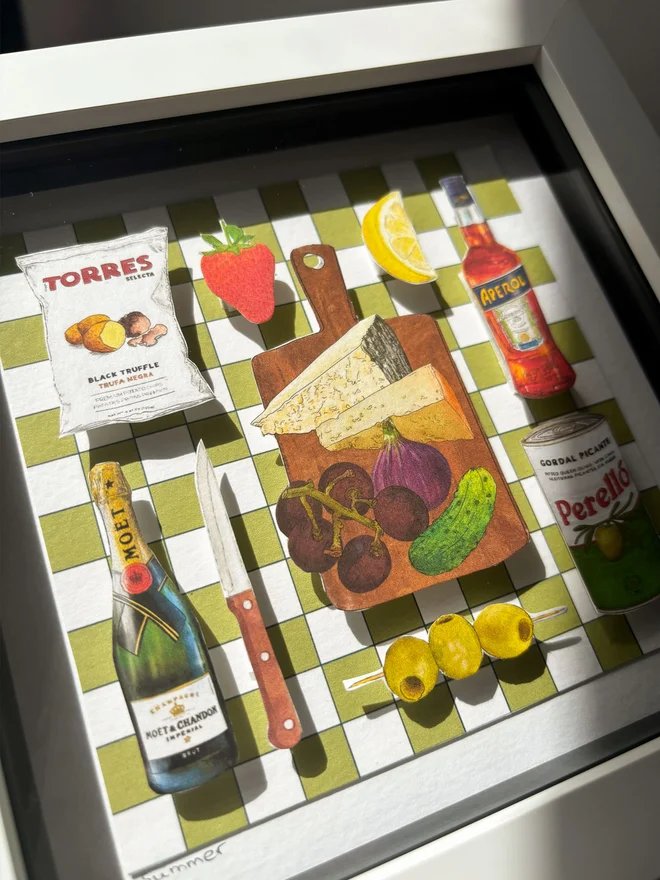 Close-Up of 3D paper collage showing a summer picnic spread on a green and white backdrop