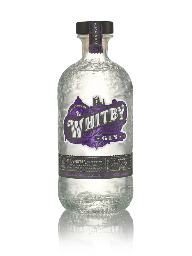 The Demeter Edition Gin, a bottle of gin sitting on a plain white surface. 