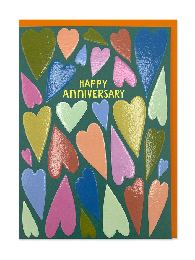 An anniversary card with a colourful hearts pattern with a ‘Happy Anniversary' message on a dark green background 