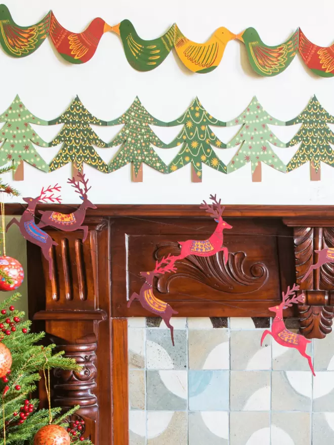 Close-up, detailed shot: reindeer garland hanging over fireplace