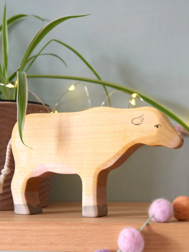 wooden cow on toy shelf