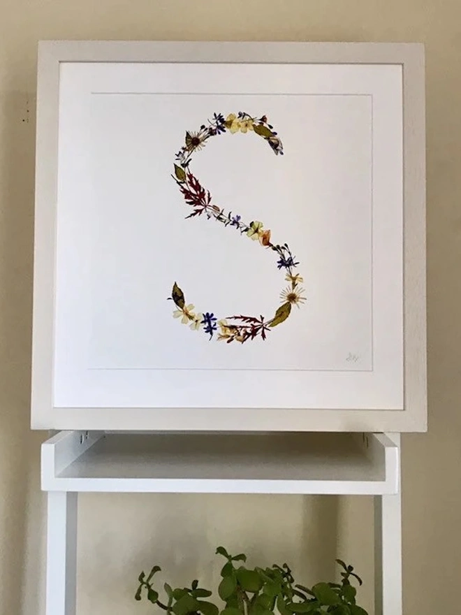 Pressed Wildflower Letter Print, a wildflower alphabet letter print sitting framed. 