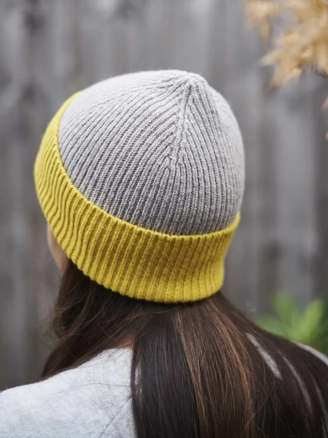 Ribbed Lambswool Women's Beanie, a woman wearing a colourful beanie outdoors. 