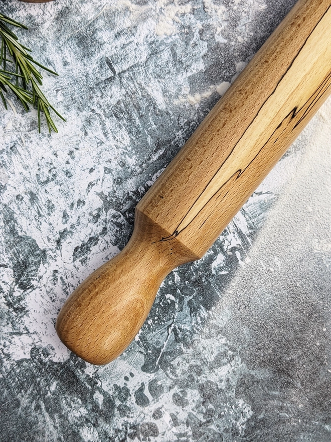 A close up of a stunning hand made rolling pin in Spalted Beech by Something From The Turnery. Displaying the all-natural flame like detailing on the left hand side of the rolling pin. 