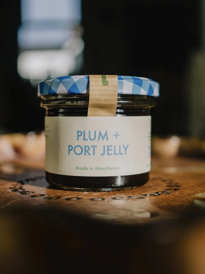 Jar Of Plum & Port Jelly, jar of jelly on a decorated plate with a blue lid. 