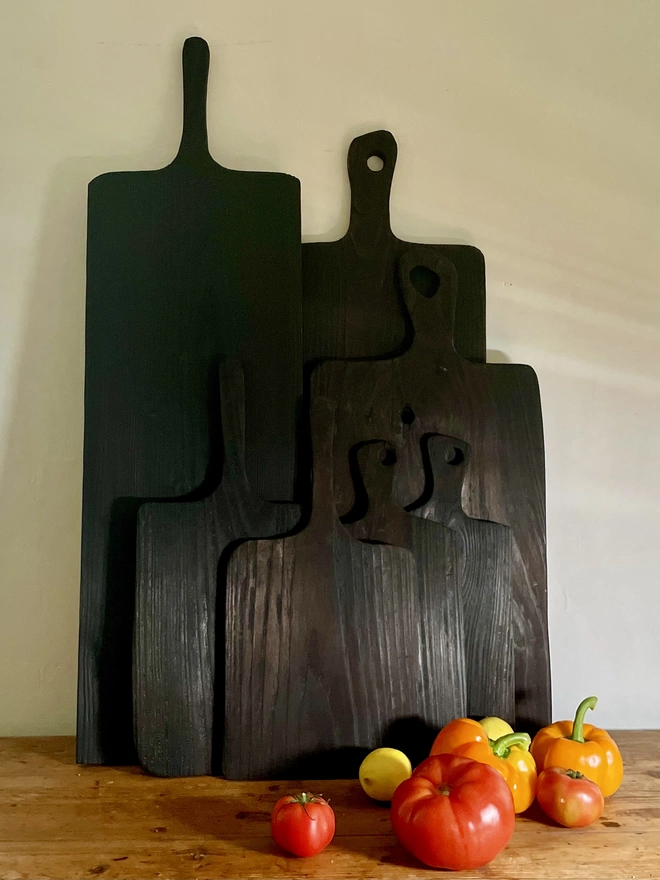Charred Yakisugi boards in various sizes styled with tomatoes 
