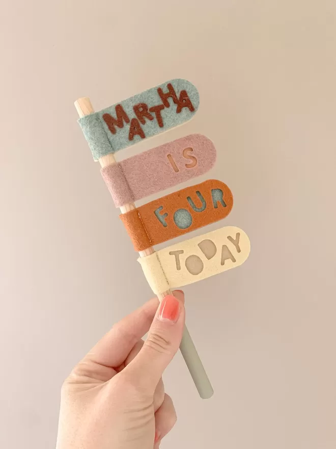 Swizzler stick in pastel shades. Tabs say Martha is four today.