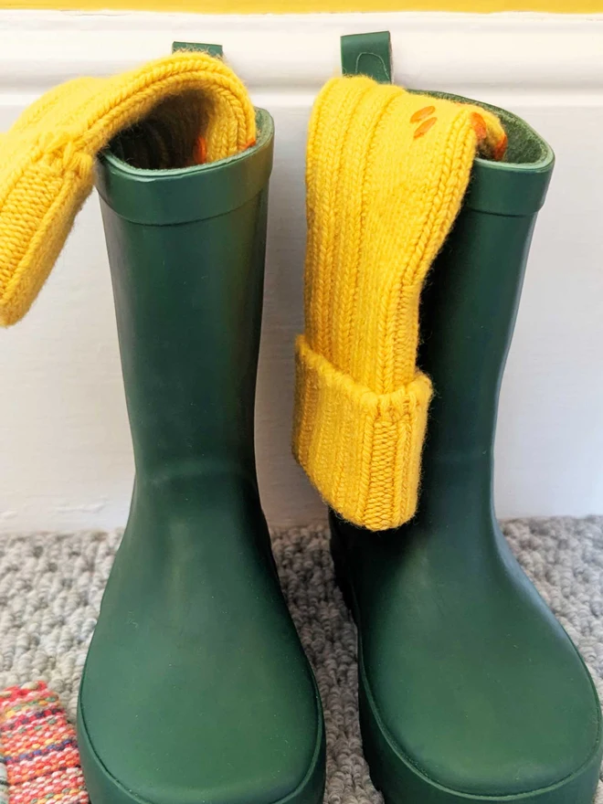 Yellow Kids Socks Displayed In Green Wellington Boots