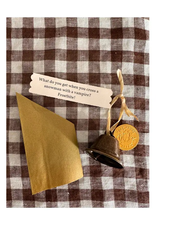 contents of cracker for filled option - gold wrapped chocolate coin, bell with joke tag, and folded paper crown