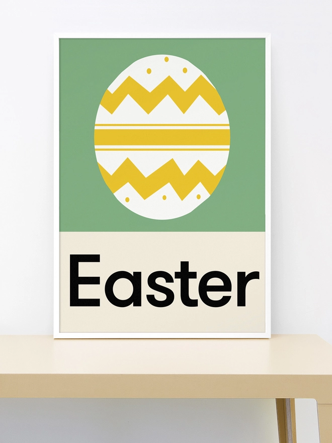 Framed print of Yellow and white patterned easter egg on green background 