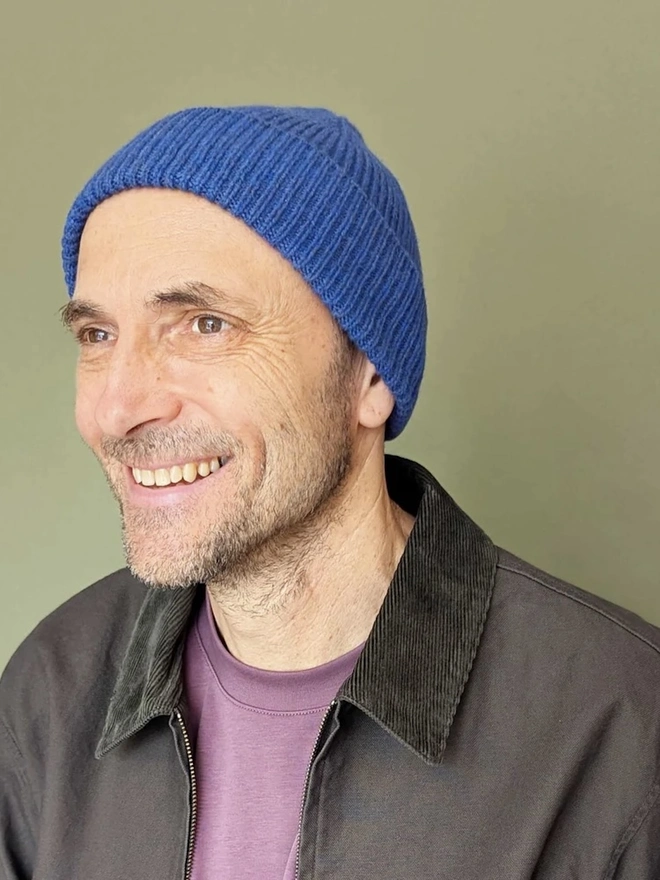 Ribbed Lambswool Men's Beanie, a person wearing a colourful ribbed beanie outdoors. 