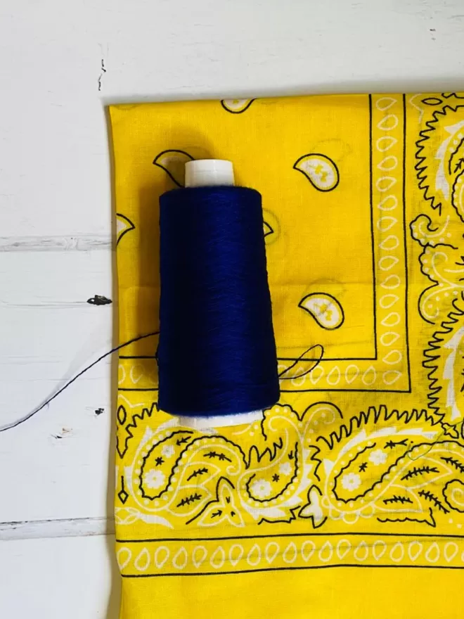 Yellow bandana with navy thread.