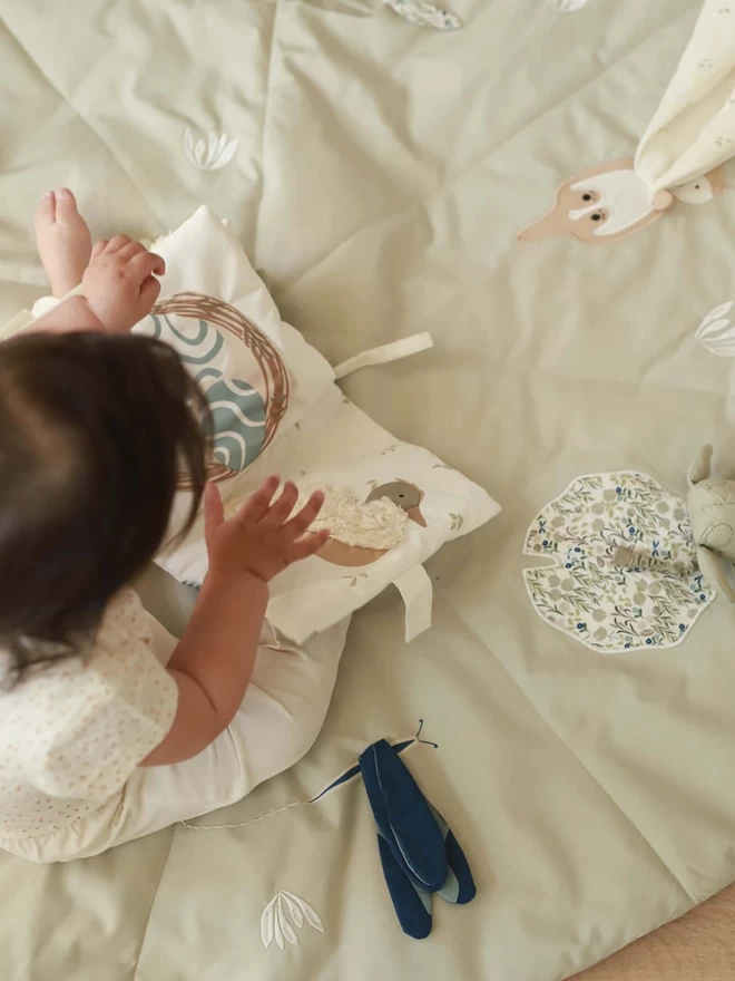 A baby playing on the activity mat riverbank