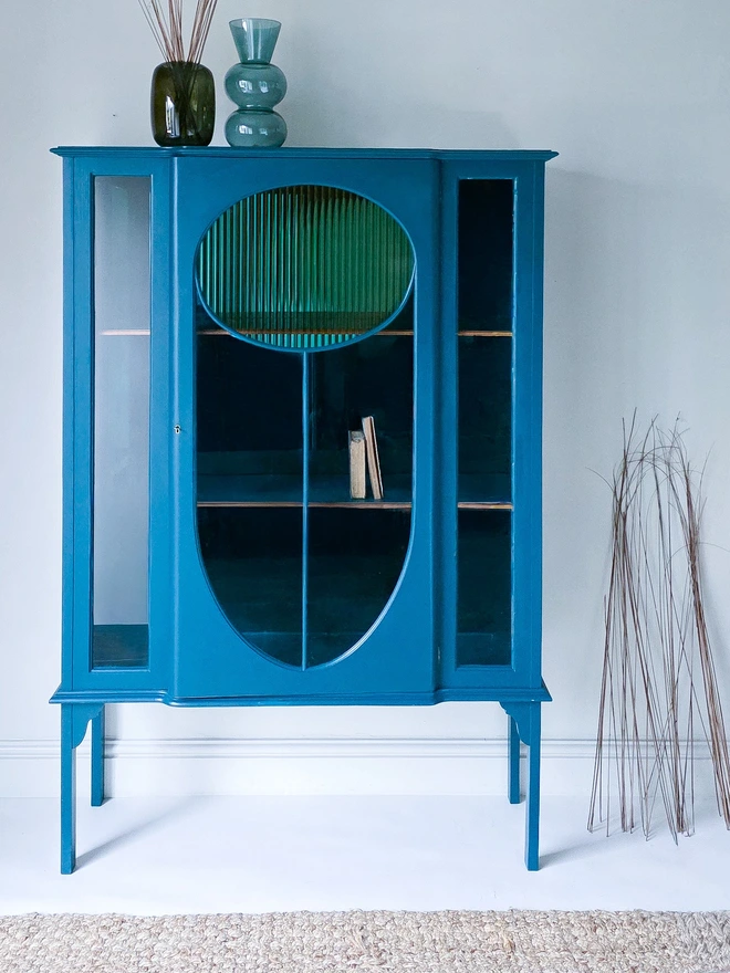 Antique Glazed Cabinet with oval shaped panel to the top in gold reeded vinyl, the back panel a vibrant mirrored teal to match the same colour paintwork