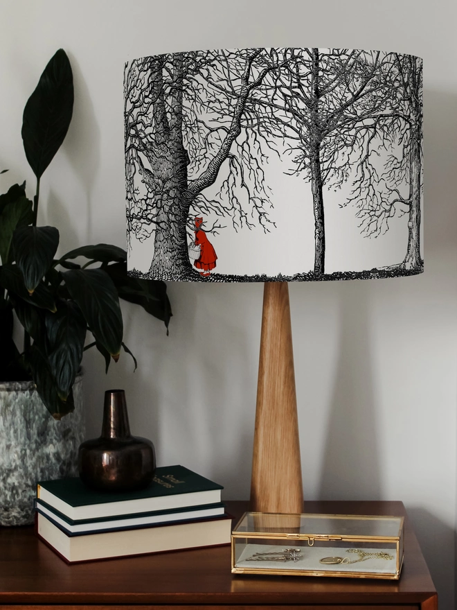 Handmade drum lampshade featuring a whimsical Little Red Riding Hood inspired design with a red cape, big bad wolf, and dark woodland scene.