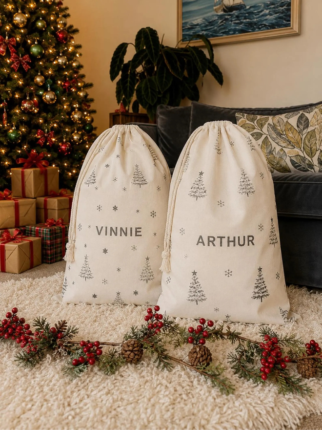 personalised drawstring christmas sack. two drawstring bags with printed christmas motifs and personalised names.