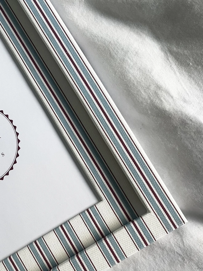 Sky & Scarlet Tailor Stripe Frame, a patterned colourful frame sitting on a plain white surface. 