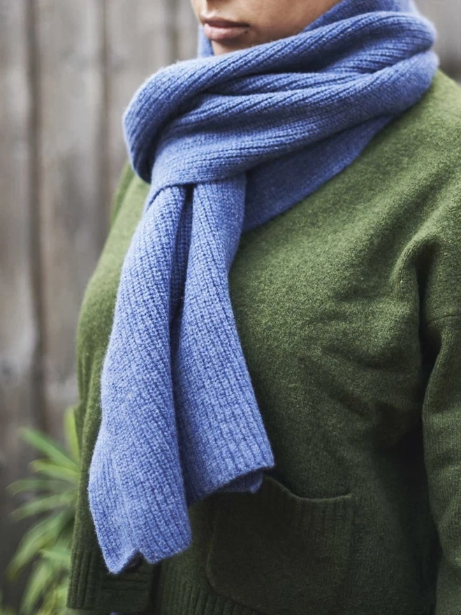 Lambswool Ribbed Scarf, a woman wearing a colourful ribbed scarf outdoors. 