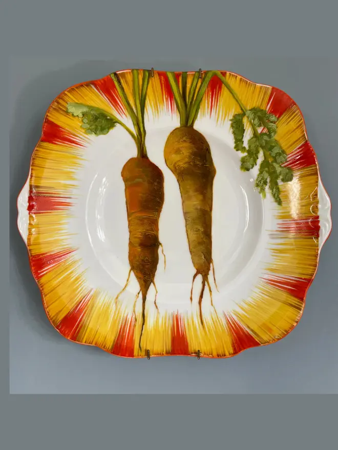 Oil Painted Two Carrots On A 1930s Cake Plate, against a grey wall. 