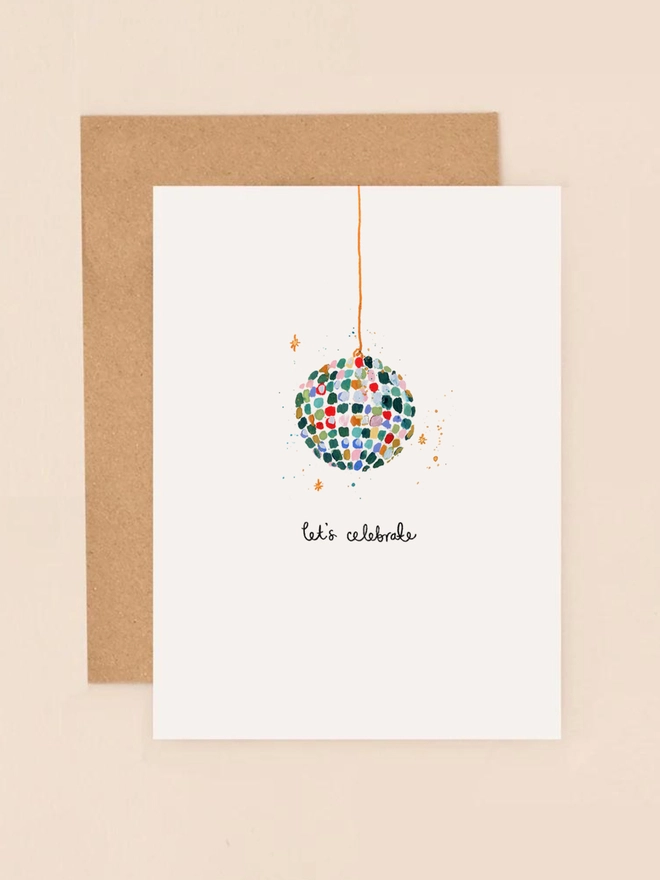A vibrant illustration featuring a sparkling disco ball adorned with colorful glitter accents, exuding a festive and celebratory atmosphere. The design is complemented by the playful message "Let's celebrate" in a whimsical, handwritten font. The combination of shimmering details and bold colors captures the excitement of a party, making this mini card a perfect choice for birthdays, anniversaries, or any occasion that calls for a touch of sparkle and joy.