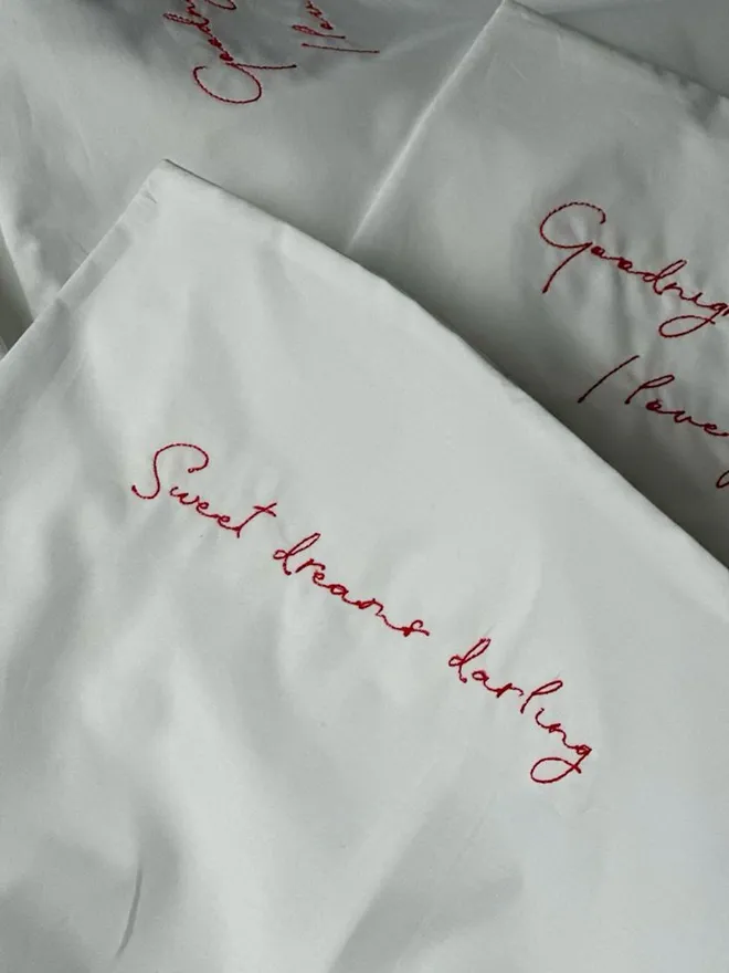 white pillowcase with embroidered red text 'Sweet Dreams Darling'