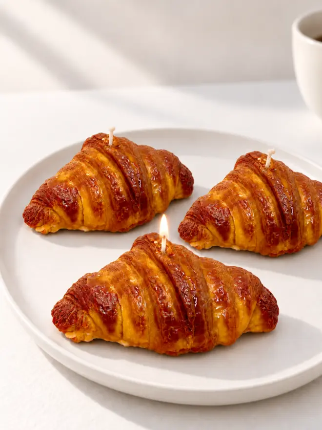 Three croissants candles on a white platter