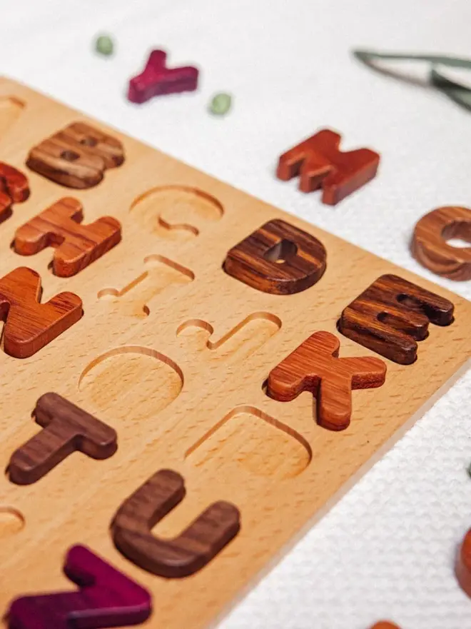 Wooden Uppercase Alphabet Puzzle Heirloom Toy, on a table. 