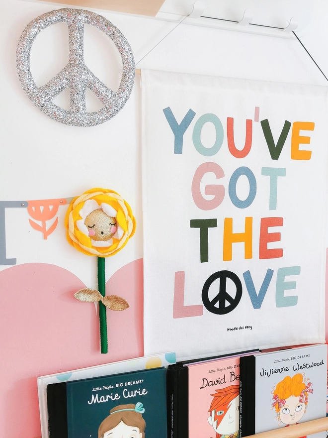 A silver glitter peace sign on a wall in a child’s bedroom