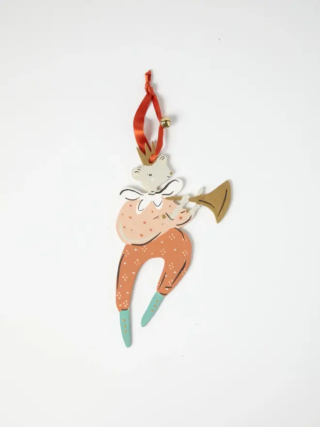 Mouse Herald Tree Dancer. a flat lay product shot of the mouse herald tree dancer hanging ornament in coral and peach tones, on a plain white background. the mouse figure wears a gold crown and a ruffled white collar, playing a gold trumpet, with spotted coral trousers ending in teal boots. the figure hangs from an orange ribbon with a small gold bell attached, giving the ornament a festive, folk-art charm.