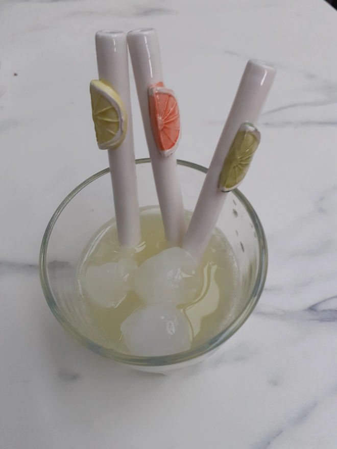 A set of three short reusable handmade ceramic drinking straws with a Citrus theme