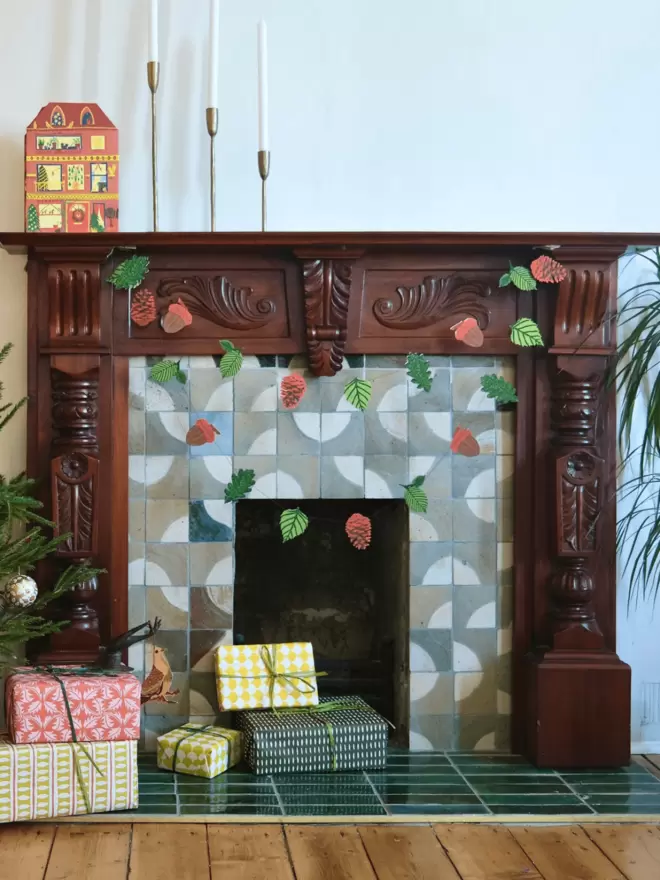 Christmas layout with garland hanging from fireplace along with wrapped presents
