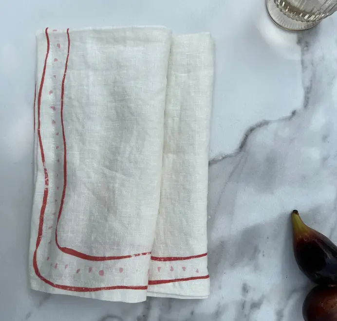 Grace Napkins (Set of 4). Light pink cloth napkin styled on a marble background.